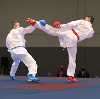 man in blue gloves parrying high kick from man in red gloves